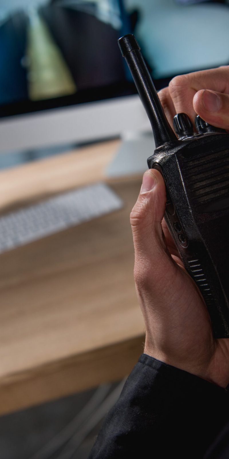 cropped view of guard holding walkie-talkie at workspace