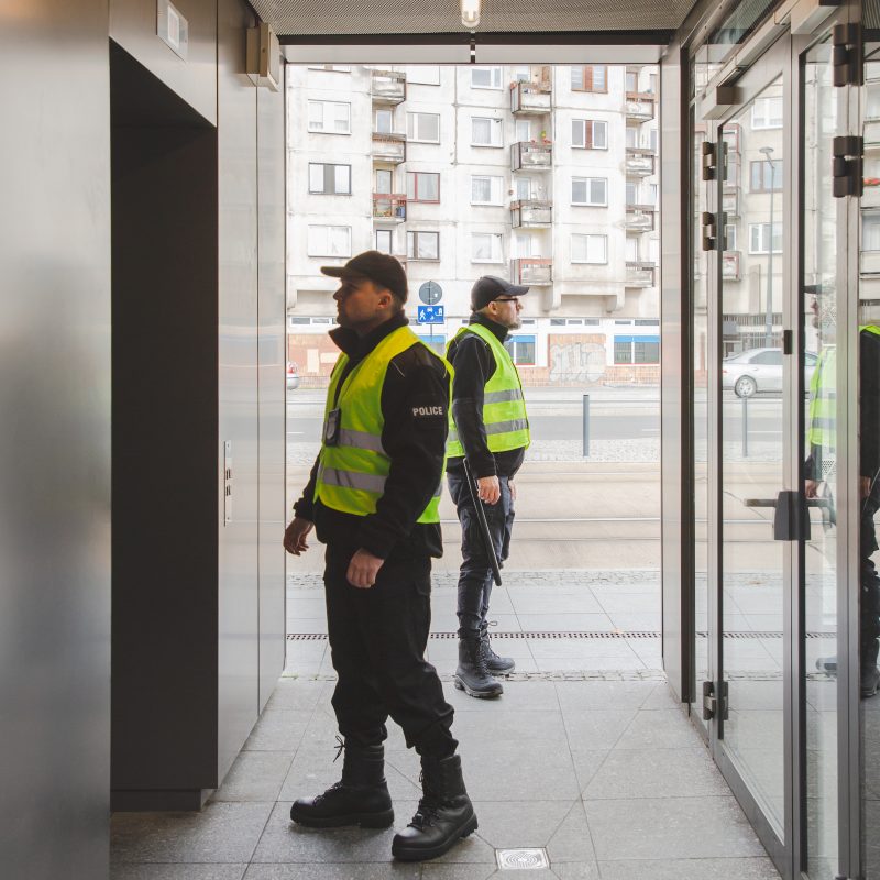 Two policemen in uniforms searching the building looking for  a suspect